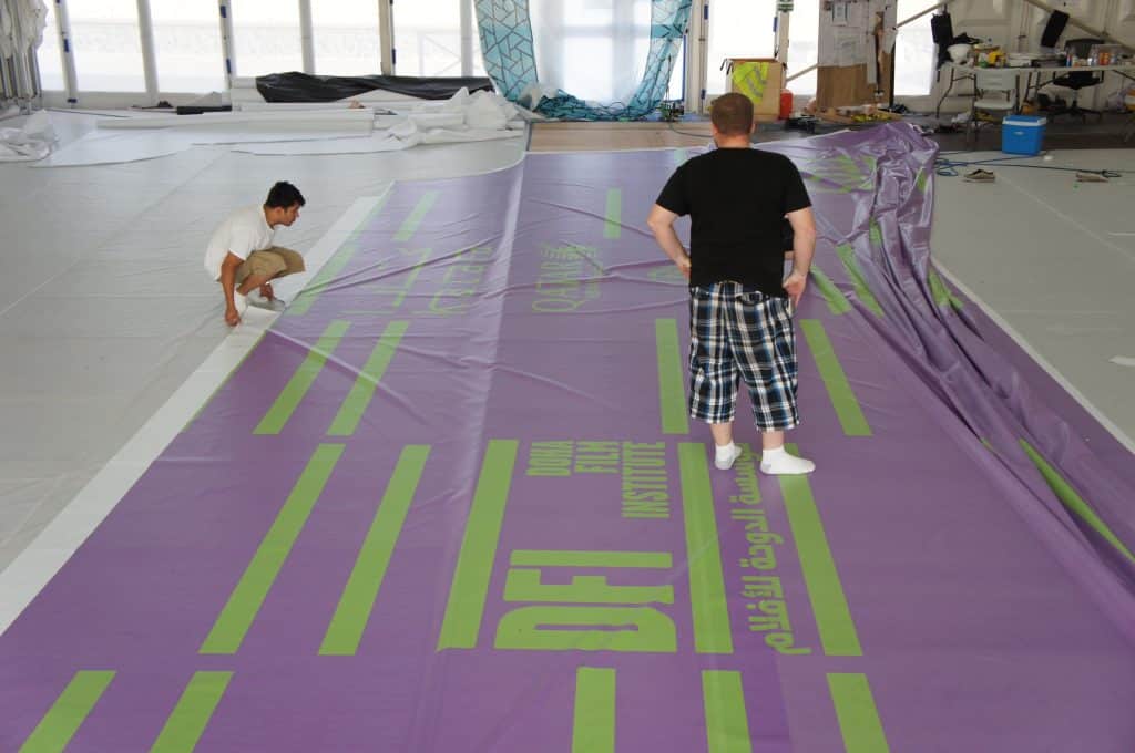 two guys working on a lavender and green panel on location for a custom event