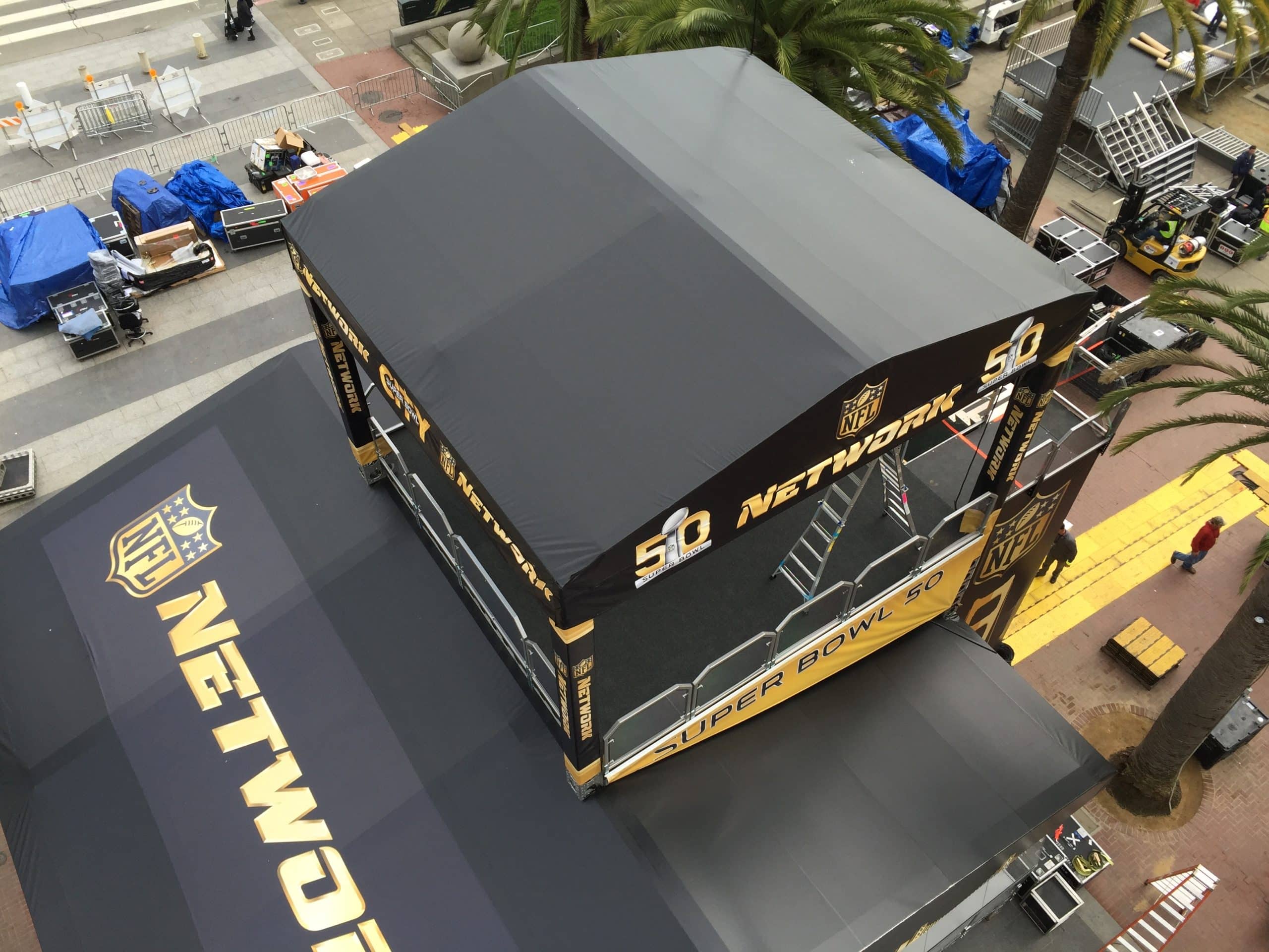 Aerial down view of black and white stage roof skins and sidewalls on multiple levels of this event structure for the NFL Network